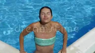 有魅力的女孩在<strong>游泳</strong>池里的摄像机上摆着身体<strong>姿势</strong>。 慢动作